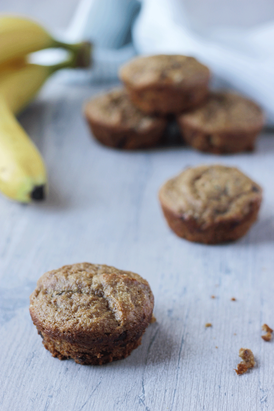 Vegan Gluten-Free Banana Muffins on a table next to a banana/