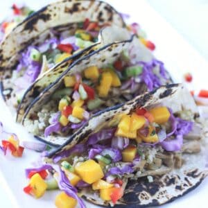 Three vegan jackfruit tacos on a plate.