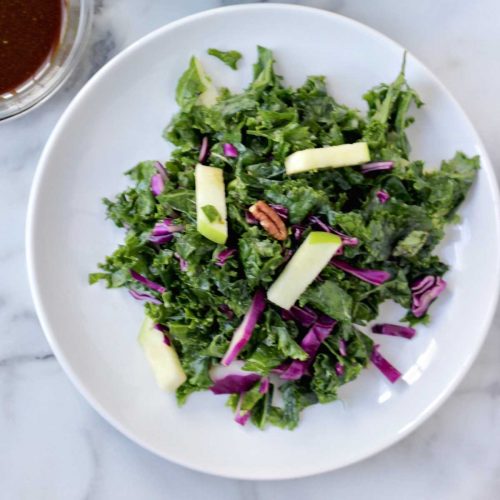 Kale salad with oil-free balsamic vinaigrette on a plate.