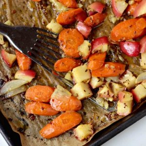 Roasted carrots and apples with a maple-mustard glaze on a sheet pan.