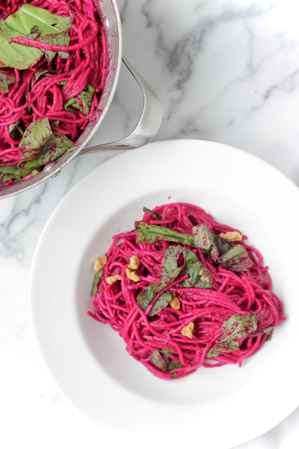 Beet pasta in a white bowl and pot