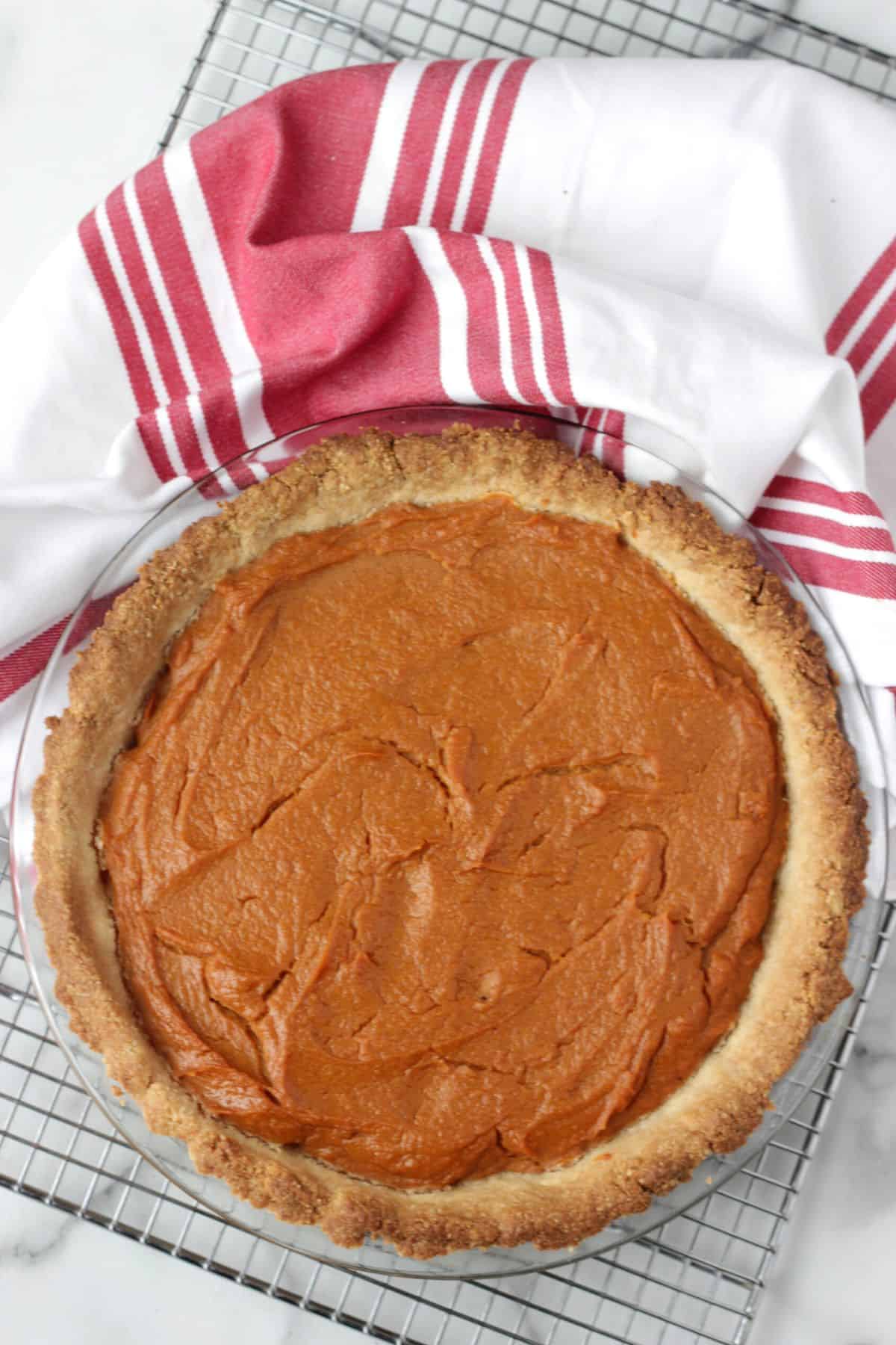 Non-dairy, eggless sweet potato pie in baking dish on cooling rack.