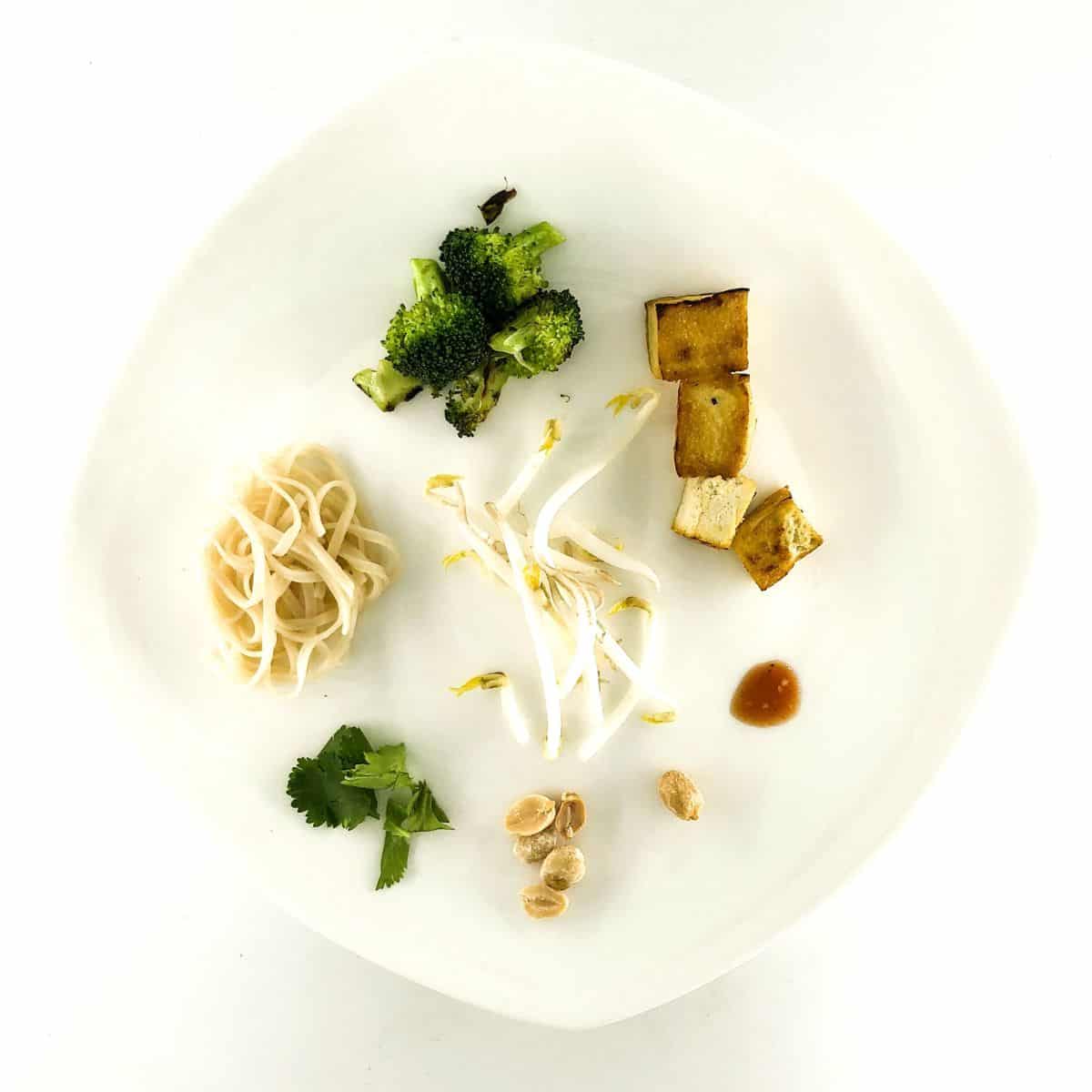 Basic ingredients to make tofu pad thai on a plate.