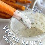 Sweet potato fry dipped in vegan ranch dressing. Glass jar filled with vegan ranch dressing, plate with sweet potato fries, and dairy-free ranch seasoning are in the background on top of a white cloth. Text reads "The Best" in fancy white lettering, "VEGAN RANCH DRESSING" in white bold font, and "ALTERNATIVEDISH.COM" at the bottom.