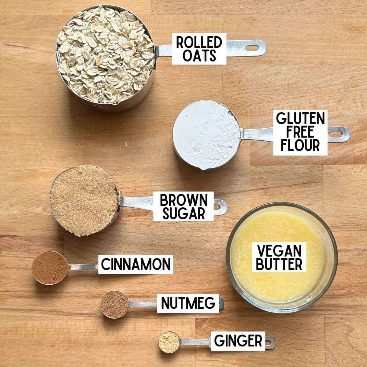 Ingredients to make the crisp topping with corresponding labels: rolled oats, gluten free flour, brown sugar, vegan butter, cinnamon, nutmeg, and ginger.