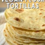 Stack of homemade flour tortillas on a white cloth. Text reads "Homemade" in fancy cursive lettering and "VEGAN FLOUR TORTILLAS" in bold block lettering.