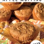 Vegan 3 ingredient apple muffin on top of a muffin liner with more fluffy muffins in the background.