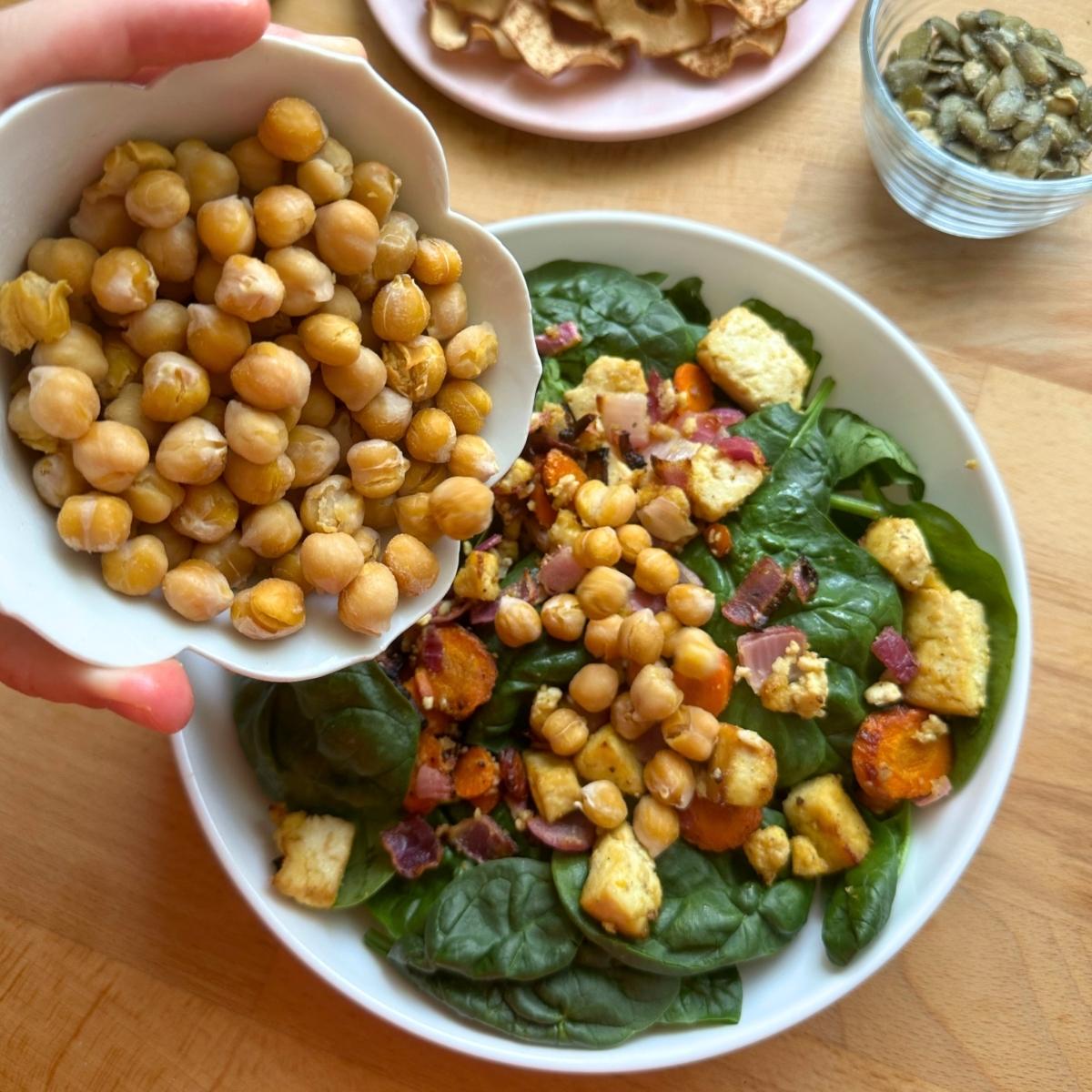Adding roasted chickpeas on top of fall harvest salad.