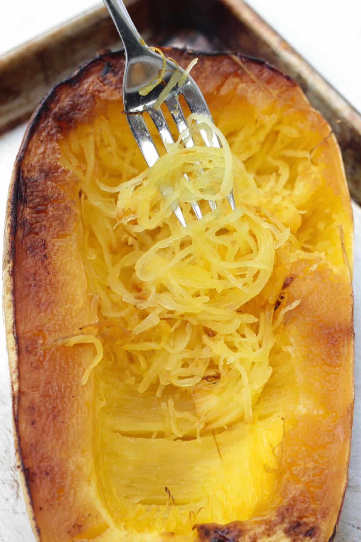 Using a fork to get spaghetti squash out after roasting.