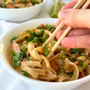 Vegan Thai peanut noodles in a bowl with chopsticks.