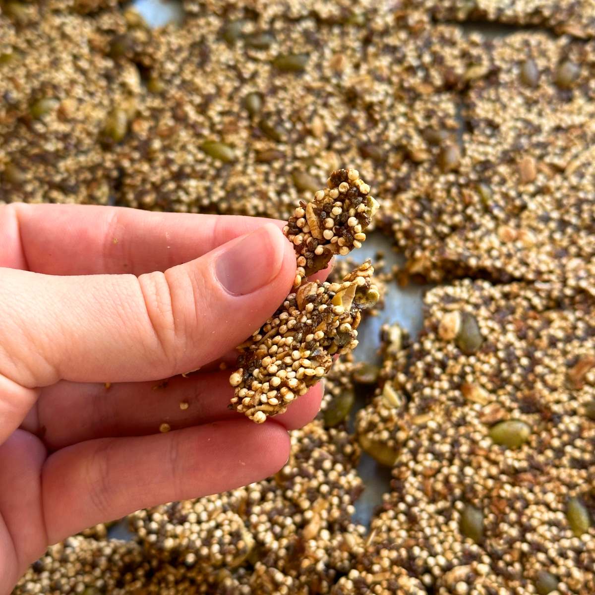 Breaking popped quinoa granola into clusters.