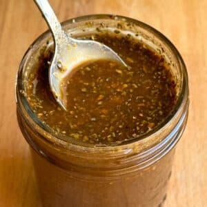 Oil free balsamic vinaigrette in a glass jar with a spoon.