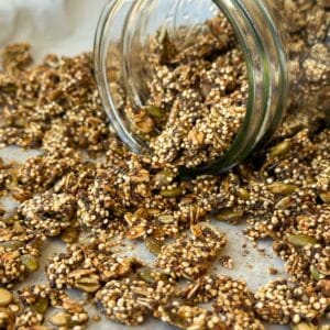 Popped quinoa granola spilling out of a glass jar.