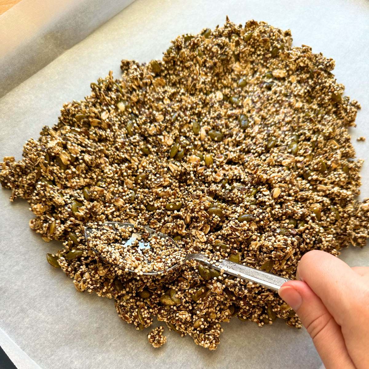 Spreading granola across baking sheet.