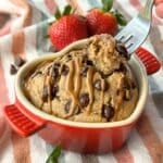 Baked oatmeal in a red heart ramekin with a fork taking out a piece.