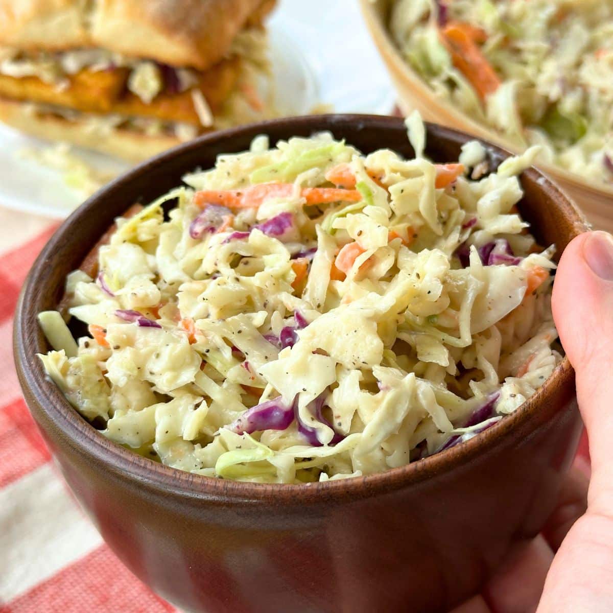 Vegan coleslaw with creamy dressing in a wooden bowl.