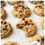 Mini chickpea chocolate chip cookies on a baking sheet with a bite taken out of one.