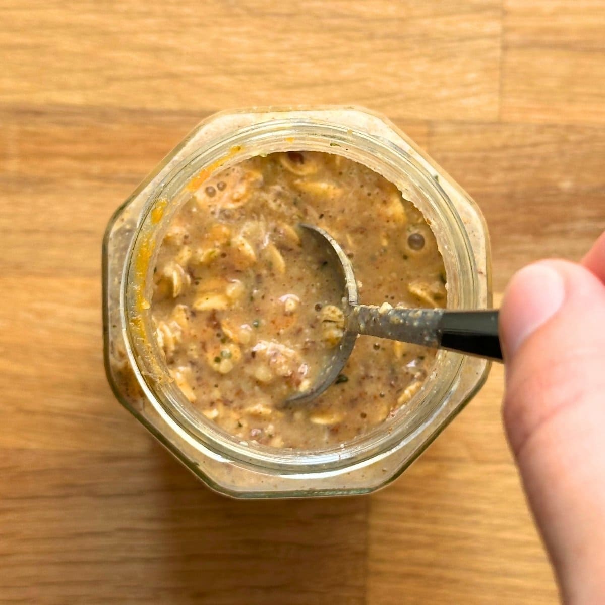 Mixing together pumpkin overnight oats with a spoon.