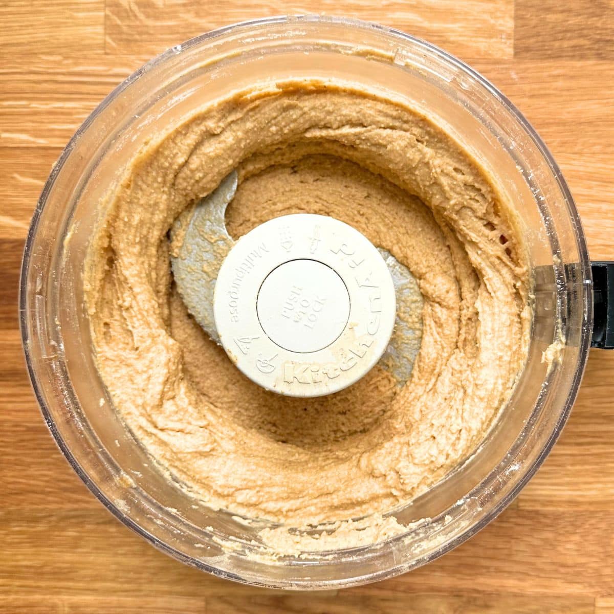 Chickpea cookie dough mixture in a food processor, slightly thicker with the addition of oat flour.
