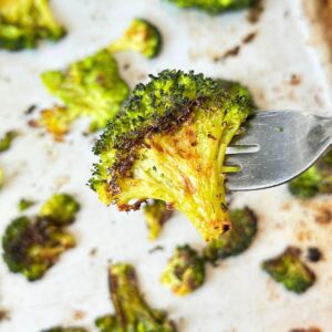 Smashed broccoli floret on a fork with crispy edges.