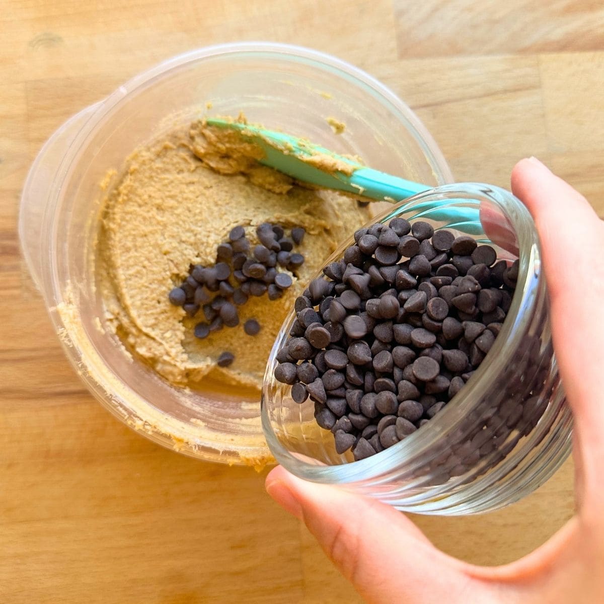 Sprinkling in mini chocolate chips to the chickpea cookie dough dip.