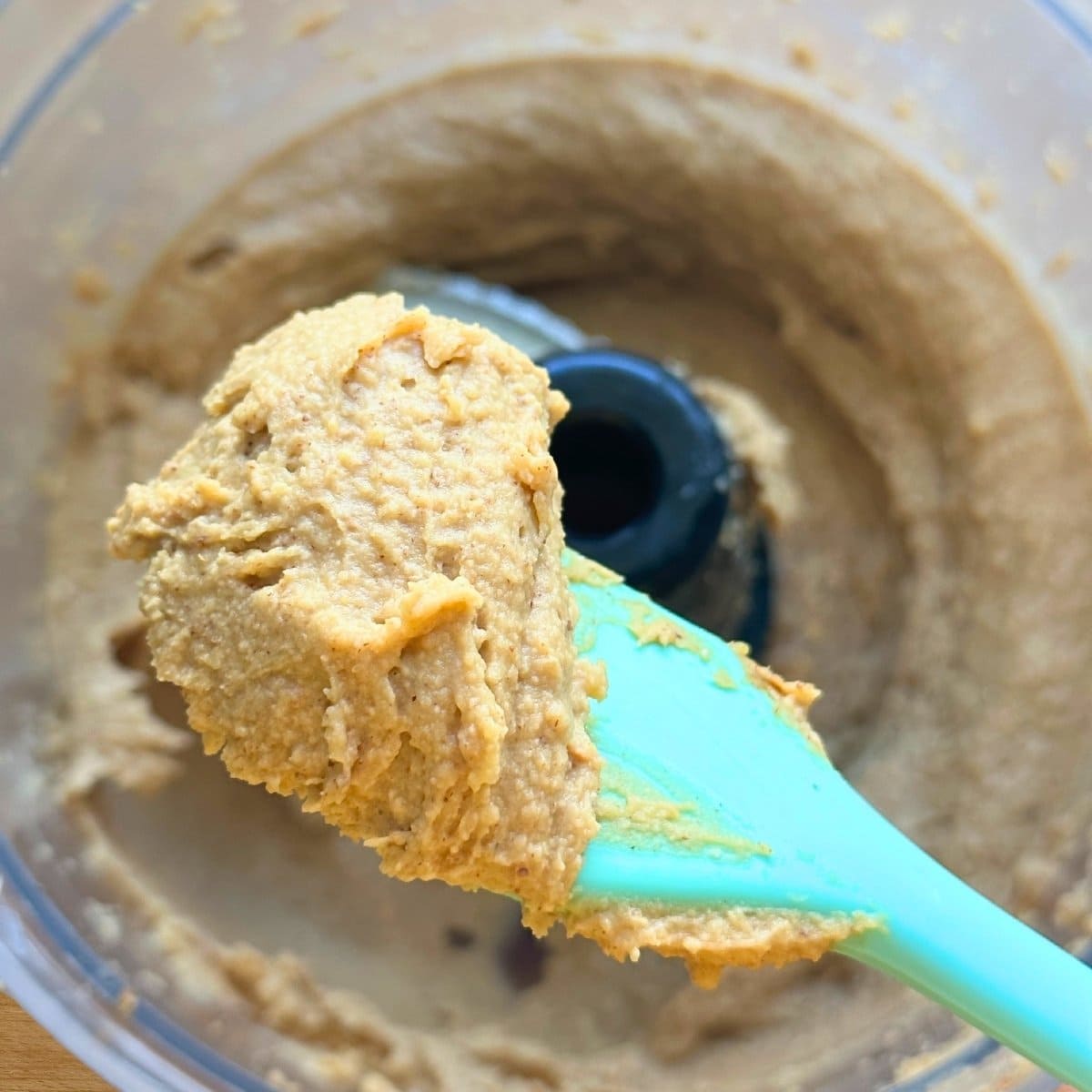 Creamy blended chickpea cookie dough on a spatula after finishing processing all of the ingredients.