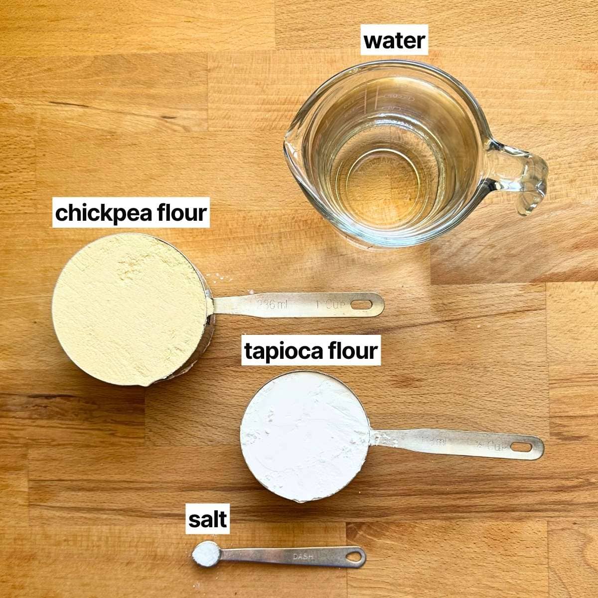 Picture of ingredients needed to make chickpea flour tortillas with corresponding written labels: water, chickpea flour, tapioca flour, and fine sea salt.