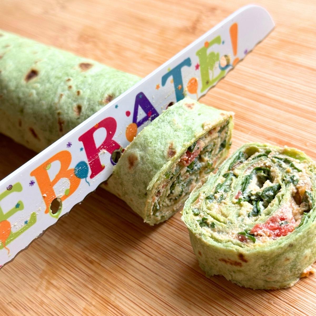 Slicing through the tortilla roll up with a knife to make bite sized pinwheel slices.