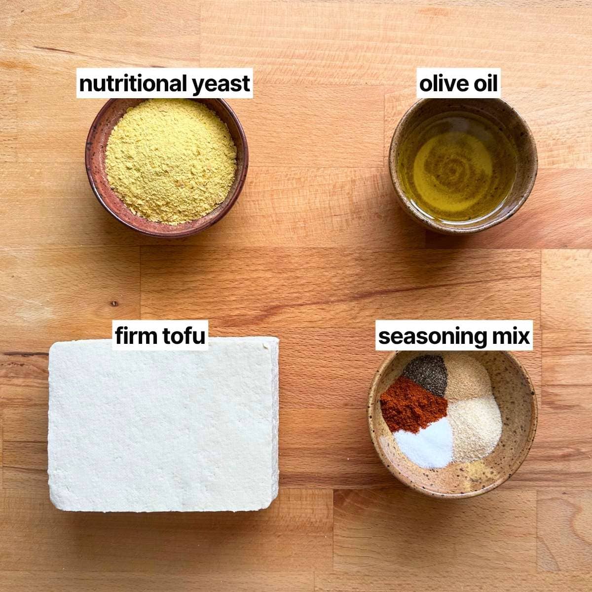 Ingredients needed to make nutritional yeast tofu with labels: nutritional yeast, olive oil, firm tofu, and seasoning.