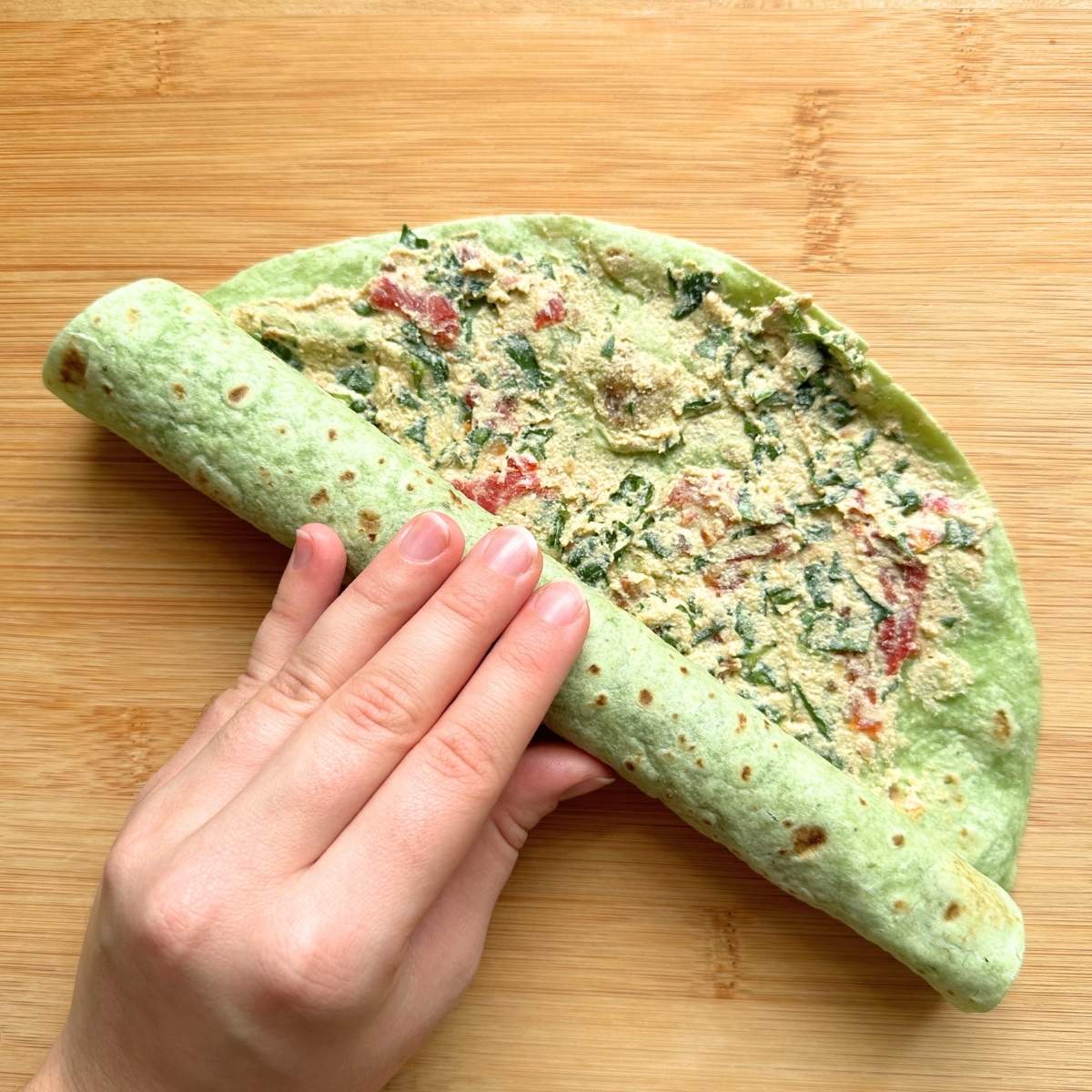 Tightly rolling the tortilla.