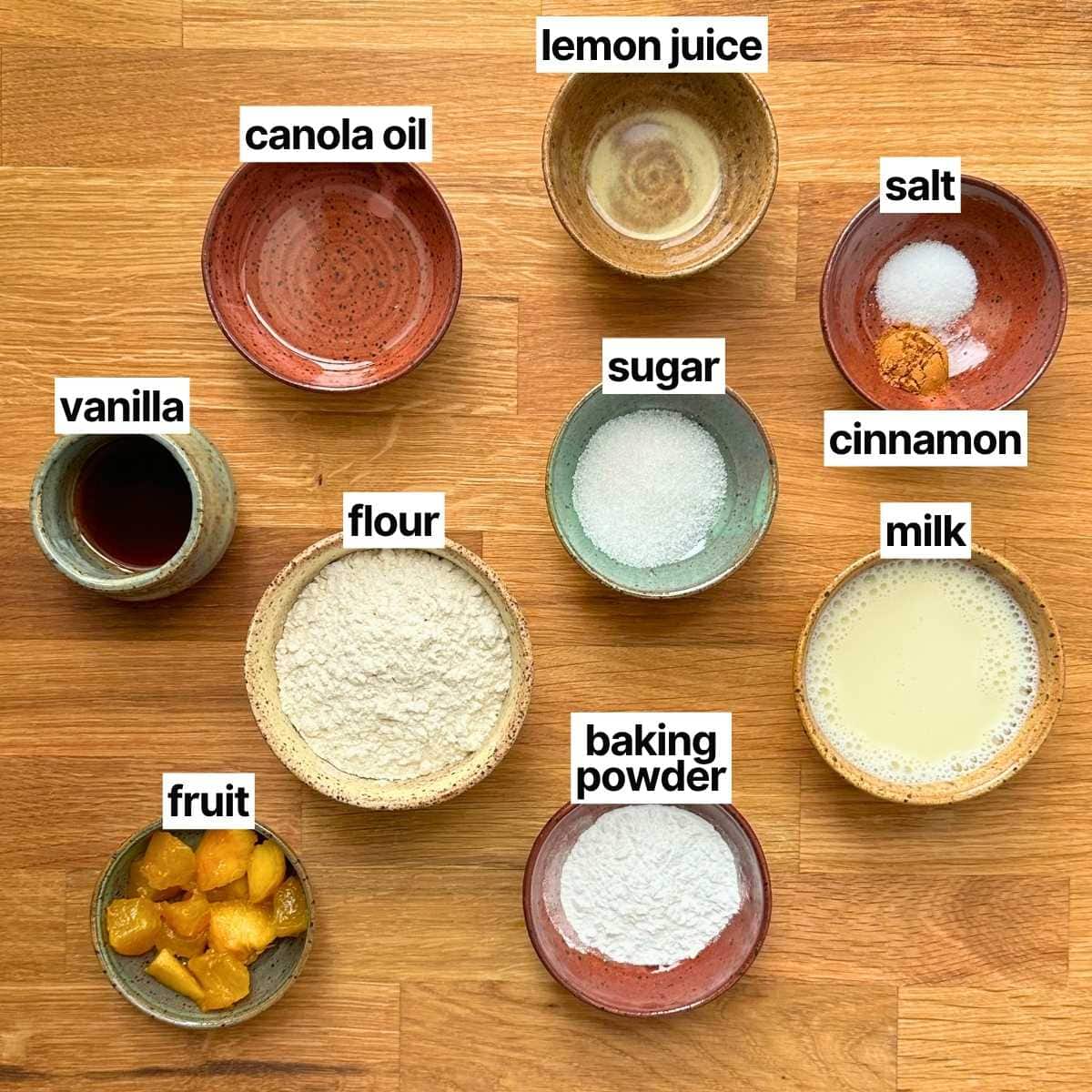 Ingredients needed to make summer pancakes: canola oil, lemon juice, salt, vanilla, flour, sugar, cinnamon, fruit, baking powder, and milk.
