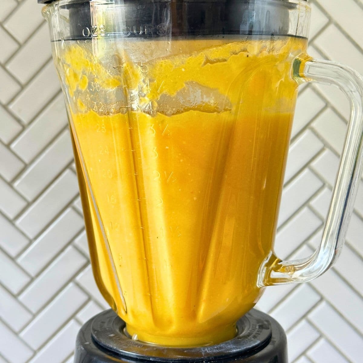 Butternuts squash soup in a blender being blended to creamy, uniform consistency.
