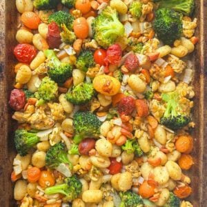 Sheet pan gnocchi with broccoli, carrots, tomatoes, and tempeh on a pan.