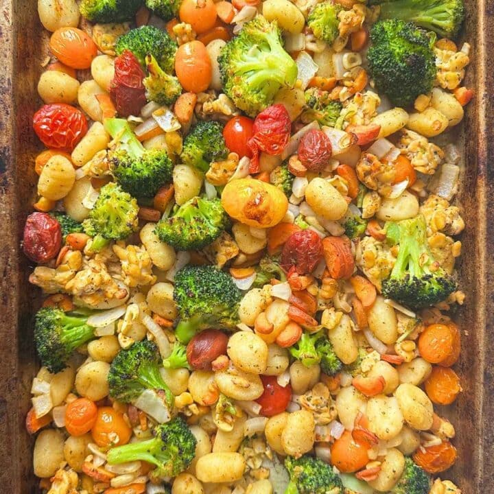 Sheet pan gnocchi with broccoli, carrots, tomatoes, and tempeh on a pan.