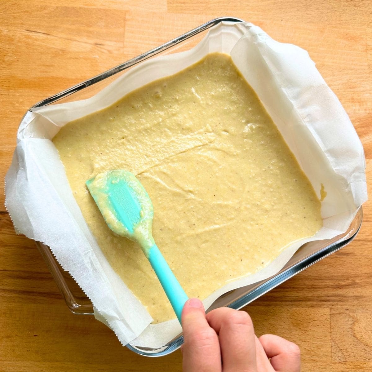 Spread cornmeal batter in glass pan lined with parchment paper.