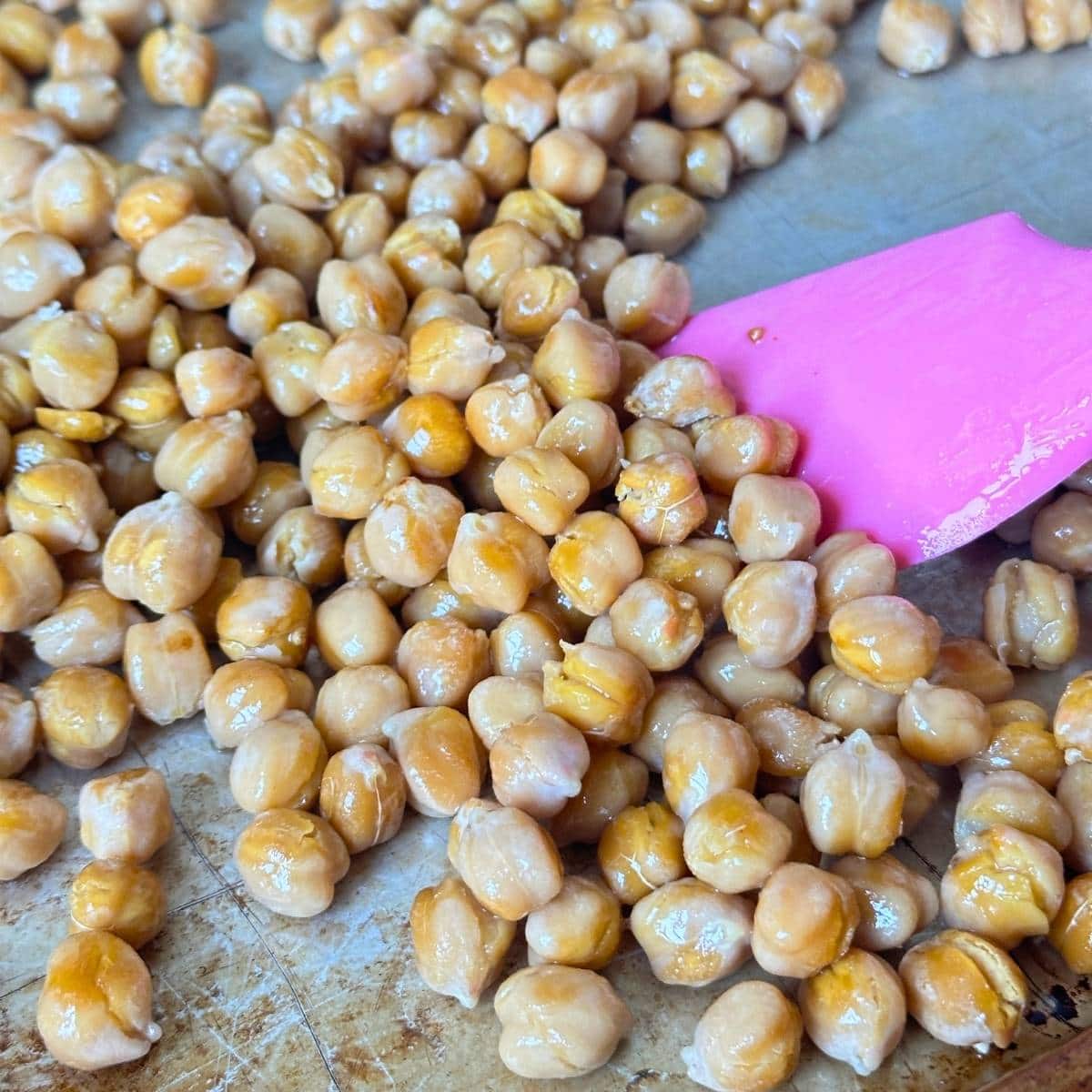 Coating dry roasted chickpeas in oil.