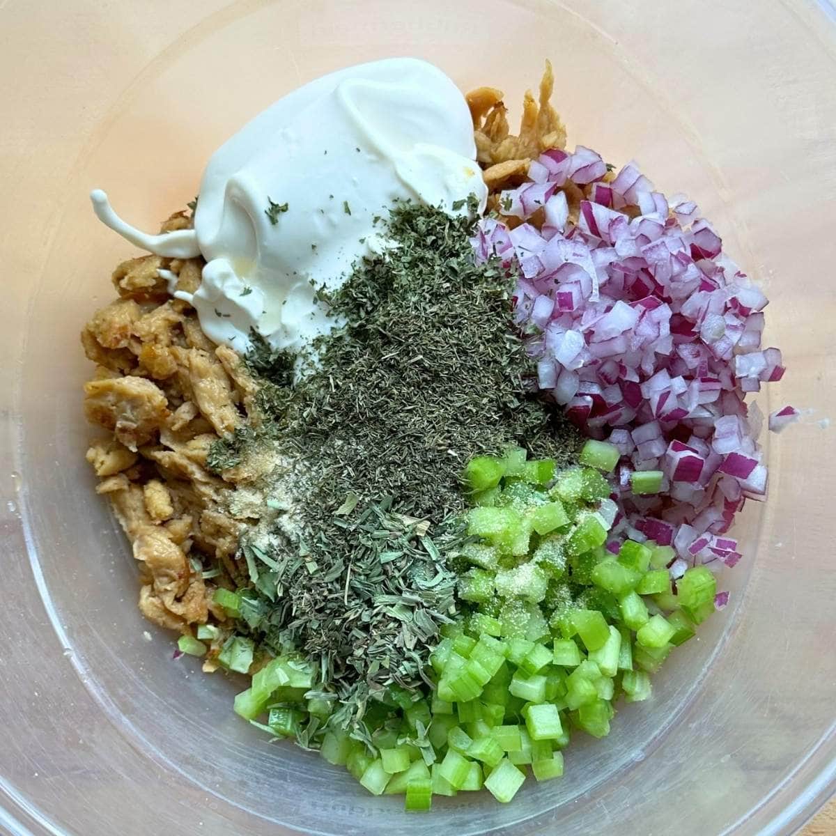 All the ingredients for soy curl chicken salad in a bowl, unmixed.