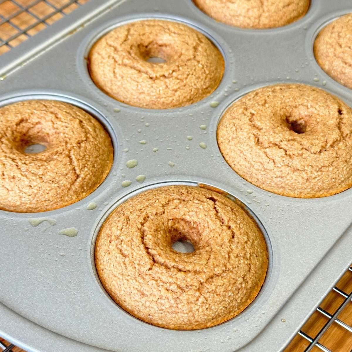 Gluten-free apple cider donuts resting in pan after being baked.