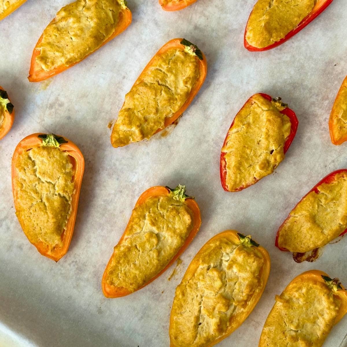Vegan mini pepper poppers baked in the oven with golden filling.