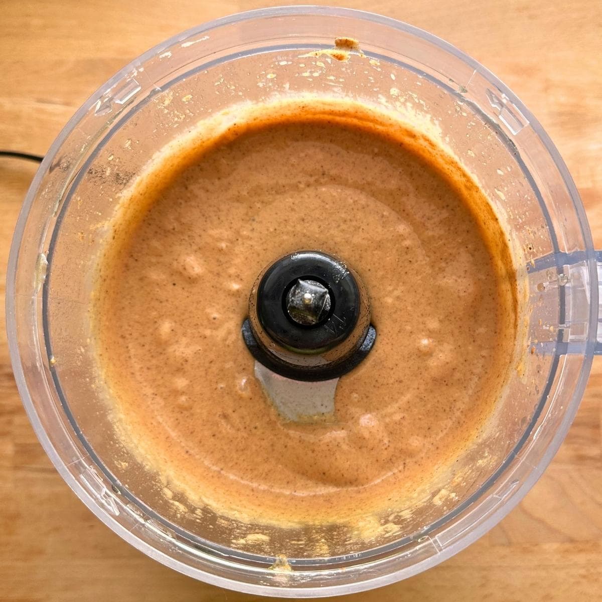 Chickpeas blended with maple syrup and almond butter in a food processor to form smooth batter.
