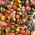 Sheet pan filled with maple dijon glazed roasted Brussels sprouts and carrots.