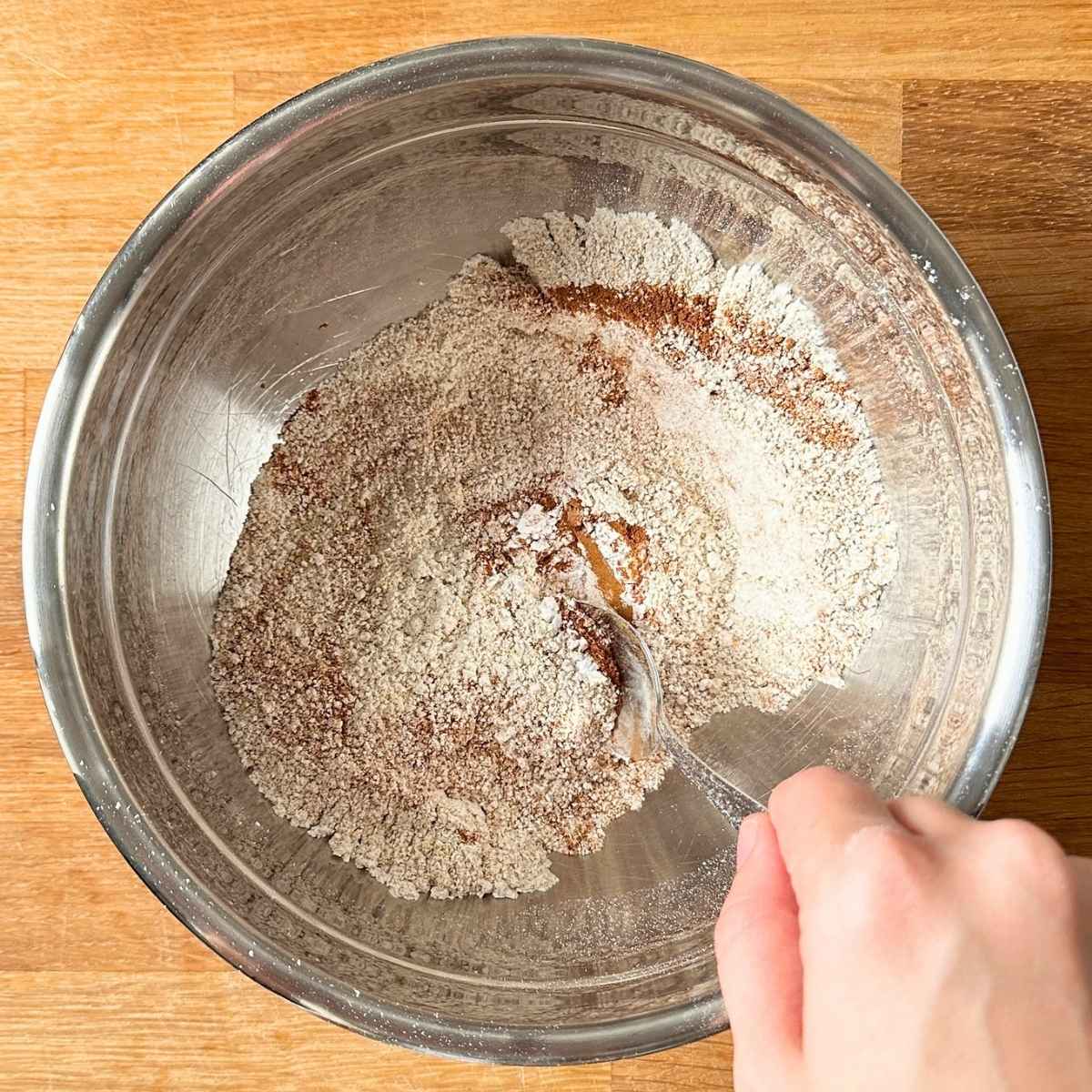 Mix dry ingredients for pumpkin cookies in a large bowl to distribute baking powder and pumpkin spice throughout.