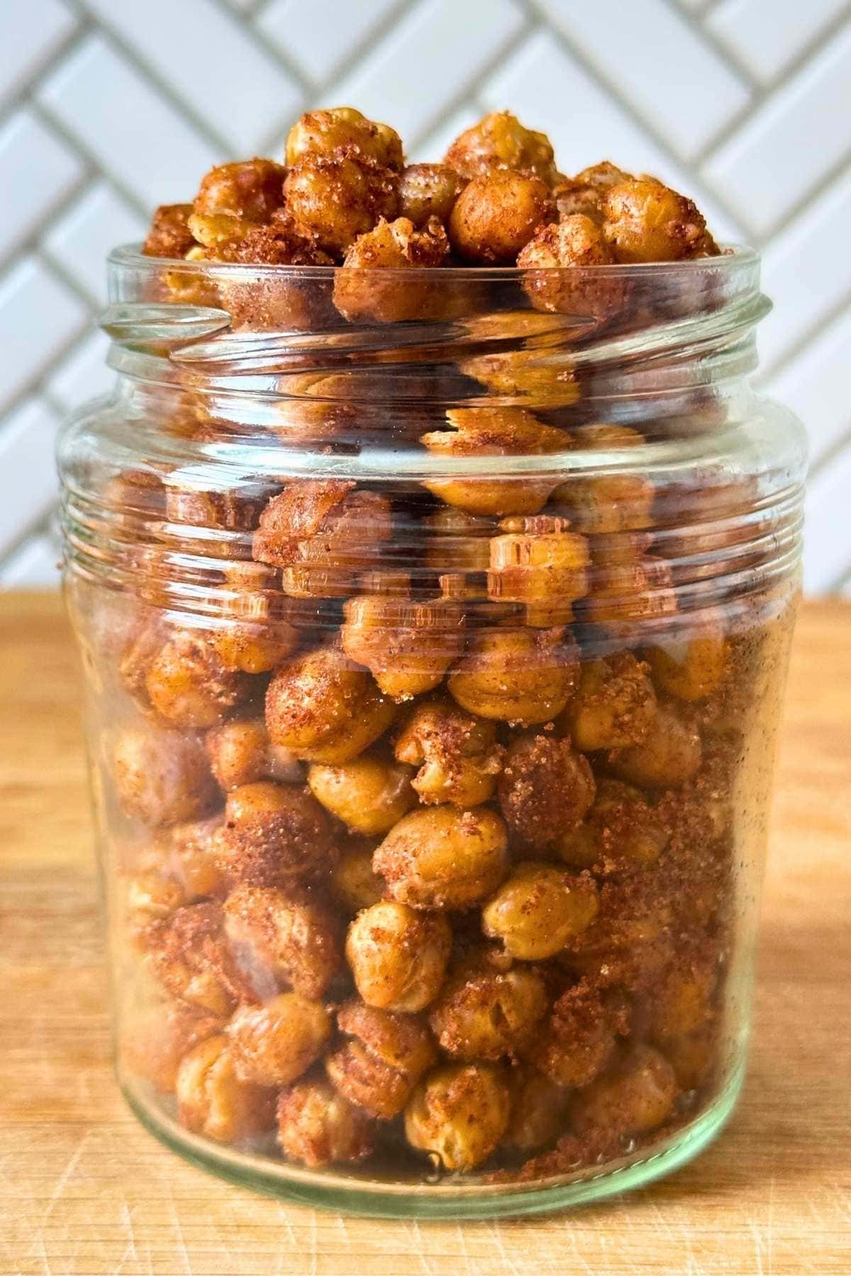 Glass jar filled with crunchy cinnamon sugar coated chickpeas.