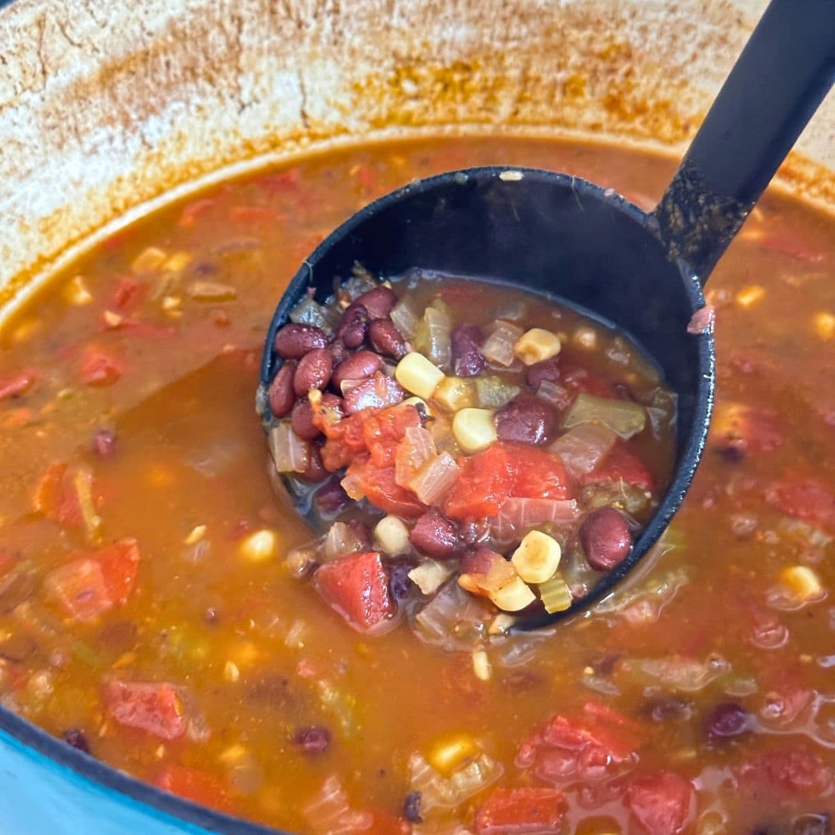 Simmer black bean tortilla soup until ingredients are softened.