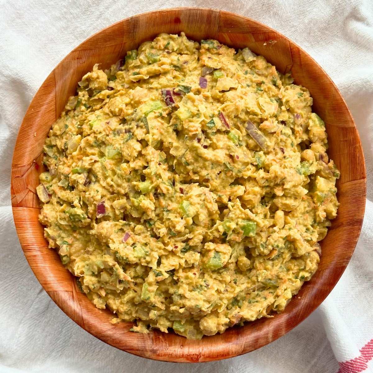 Bowl of vegan chickpea chicken salad on top of a white cloth background.