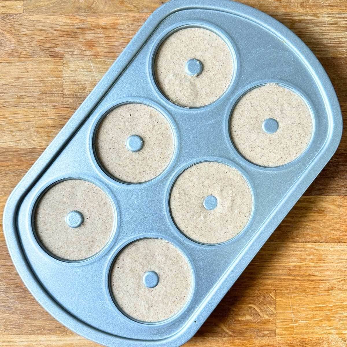 Apple cider donut batter in donut pan, unbaked.