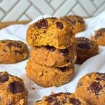 Stack of three vegan gluten-free pumpkin cookies with a bite taken out of the top one.