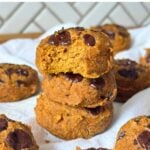 Stack of three vegan gluten-free pumpkin cookies with a bite taken out of the top one.