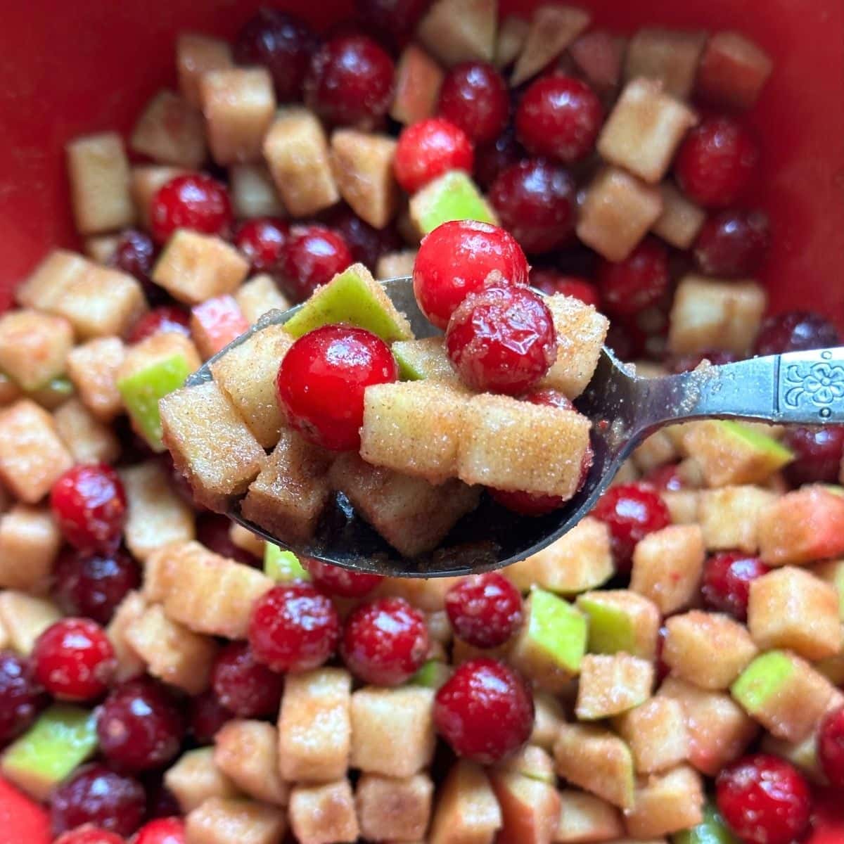 Apple cranberry filling mixed with sugar in a bowl.