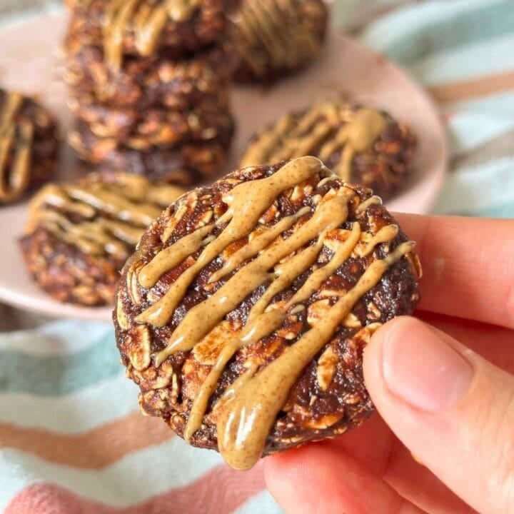 No-bake date cookie with almond butter drizzled on top, more cookies are in the background.